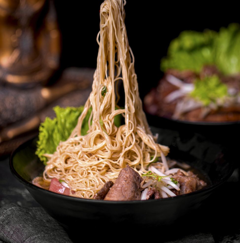 nudles in a bowl being dragged upwards