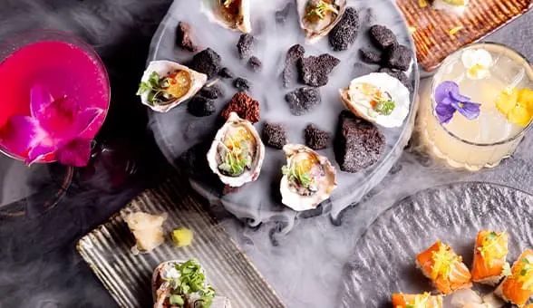 mussels on a plate and two drinks with flowers in